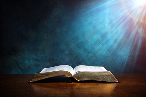 Open Bible on a Wood Table with Light Open Bible on a Wood Table with Light